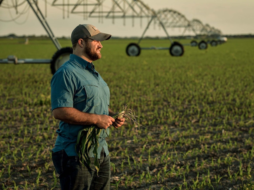 Farmer in field with irrigation equipment