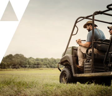 Farmers riding around land on side-by-side